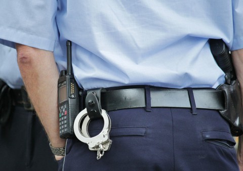 Ein Polizist mit Handschellen am Gürtel.